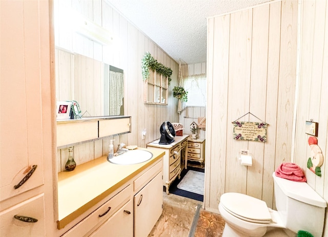 904 W 12th St, Cisco, TX 76437 - bathroom featuring vanity, a textured ceiling, and wooden walls