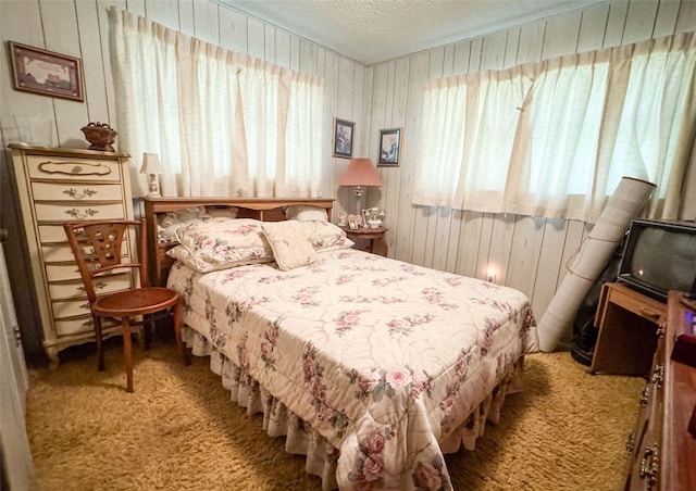 904 W 12th St, Cisco, TX 76437 - carpeted bedroom featuring wooden walls and a textured ceiling