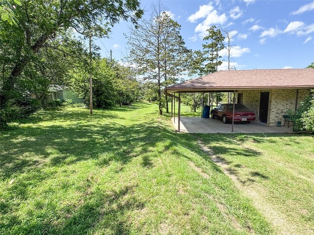 904 W 12th St, Cisco, TX 76437 - view of green lawn with a carport and driveway