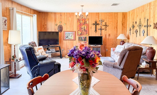 904 W 12th St, Cisco, TX 76437 - living room with wooden walls, a chandelier, a textured ceiling, and carpet flooring