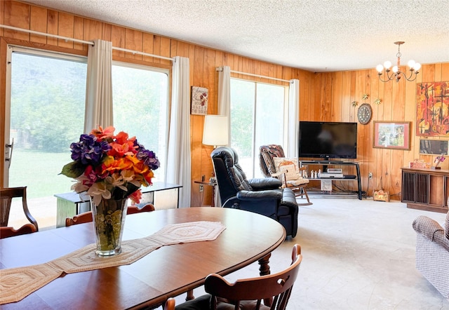 904 W 12th St, Cisco, TX 76437 - dining room with wooden walls, a chandelier, and a textured ceiling