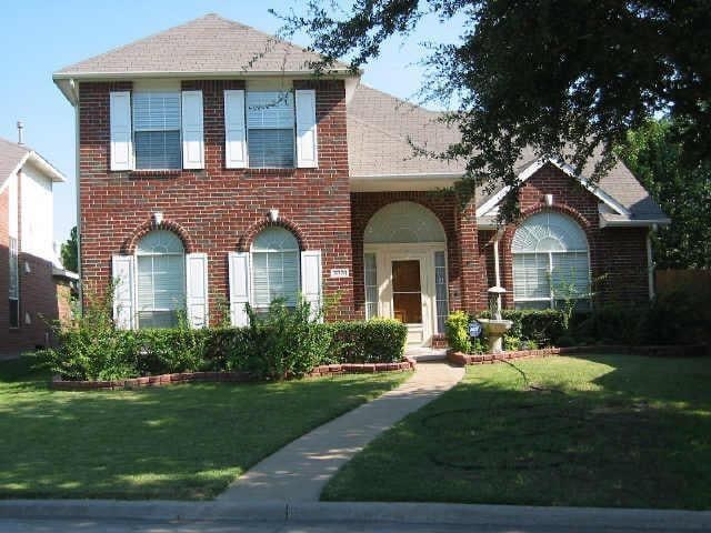 3001 Penstemon Ct, Garland, TX 75040 - view of front of home featuring brick siding, a front yard, and roof with shingles