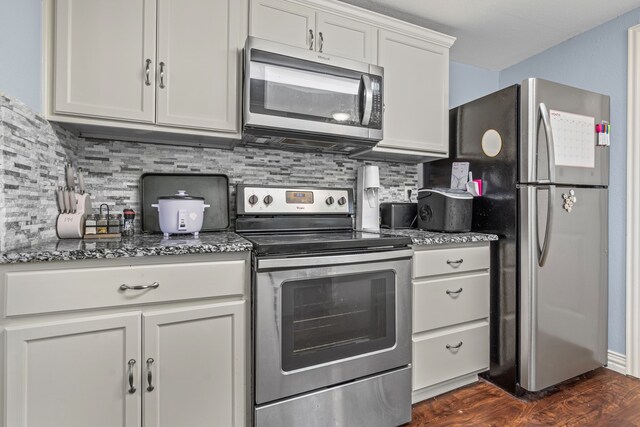 211 Second St, Denton, TX 76201 - kitchen featuring appliances with stainless steel finishes, stone counters, decorative backsplash, and white cabinetry