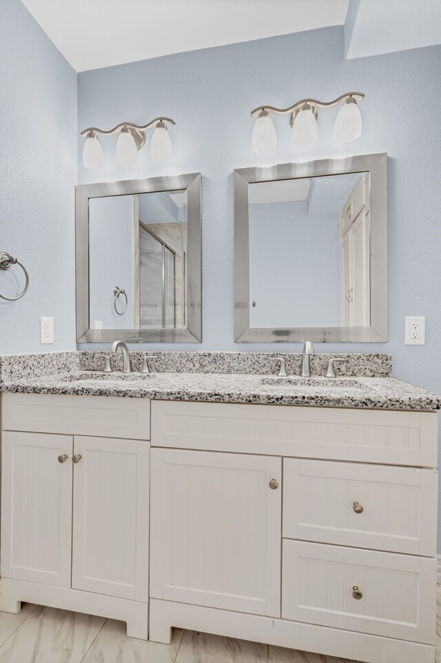 211 Second St, Denton, TX 76201 - full bathroom featuring double vanity, a stall shower, and marble look tiles