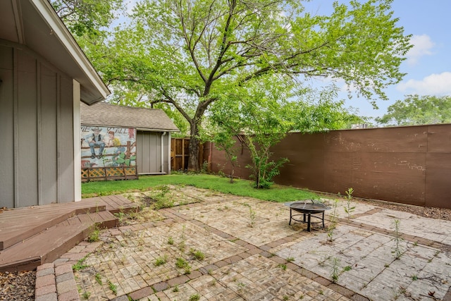 211 Second St, Denton, TX 76201 - fenced backyard with a fire pit, a patio area, a shed, and a wooden deck