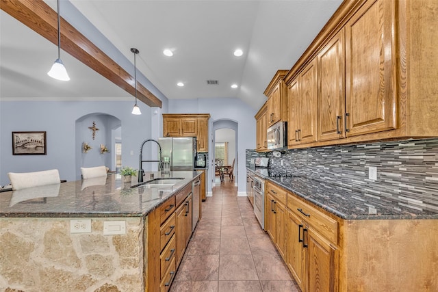 224 Cimmarron Vista Ct, Runaway Bay, TX 76426 - kitchen with arched walkways, appliances with stainless steel finishes, backsplash, dark stone countertops, and brown cabinets