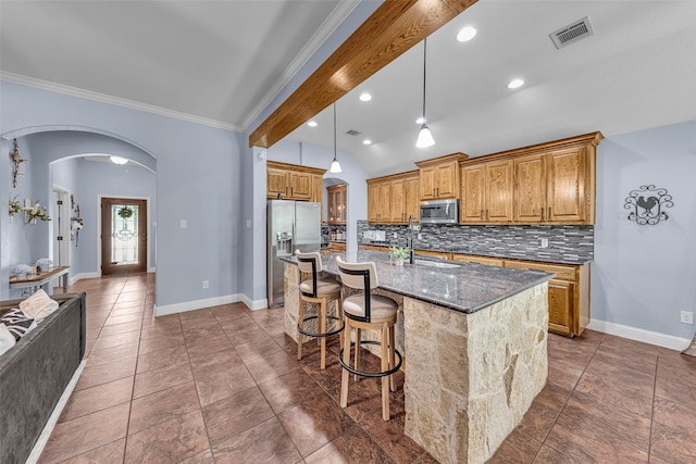 224 Cimmarron Vista Ct, Runaway Bay, TX 76426 - kitchen with stainless steel appliances, arched walkways, backsplash, dark stone countertops, and a kitchen bar