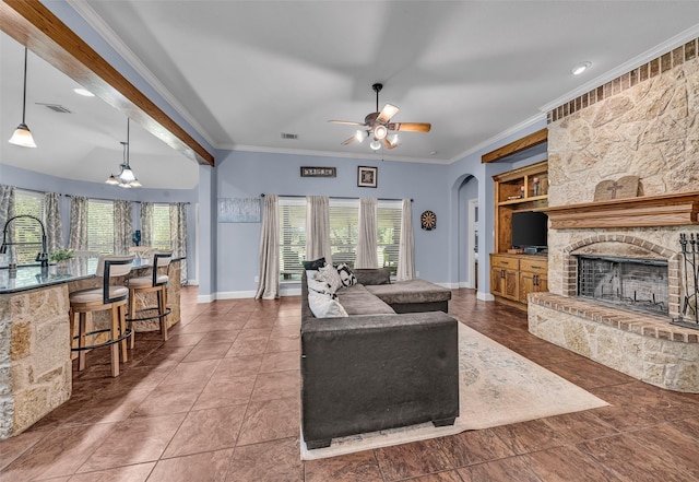 224 Cimmarron Vista Ct, Runaway Bay, TX 76426 - living room featuring arched walkways, ceiling fan, crown molding, a fireplace, and tile patterned flooring