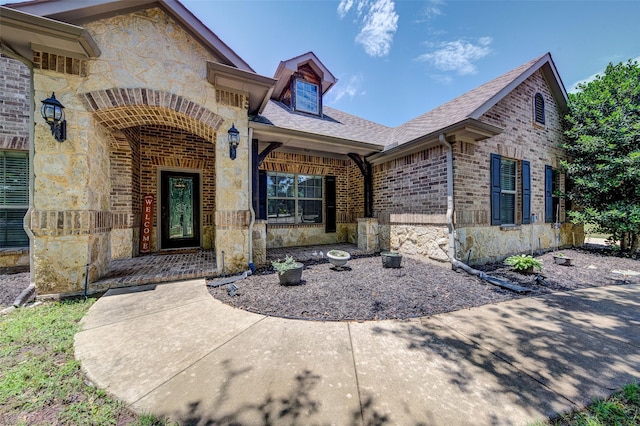 224 Cimmarron Vista Ct, Runaway Bay, TX 76426 - view of exterior entry featuring stone siding, roof with shingles, and a porch