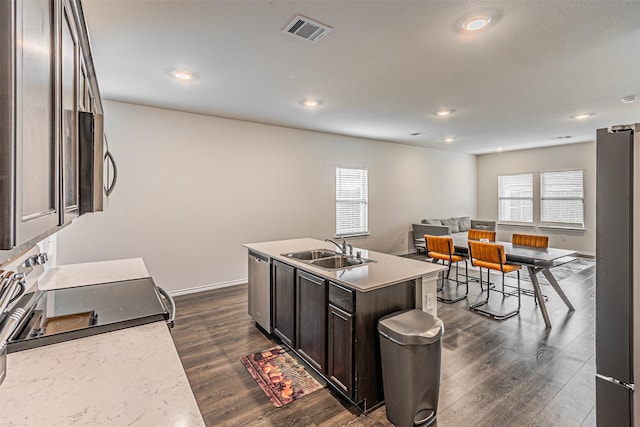 3233 Perman Dr, Mesquite, TX 75126 - kitchen featuring stainless steel microwave, dark wood-type flooring, dark brown cabinetry, open floor plan, and freestanding refrigerator