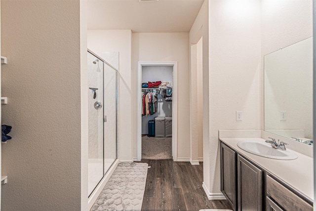3233 Perman Dr, Mesquite, TX 75126 - bathroom with wood finished floors, a stall shower, vanity, and a walk in closet