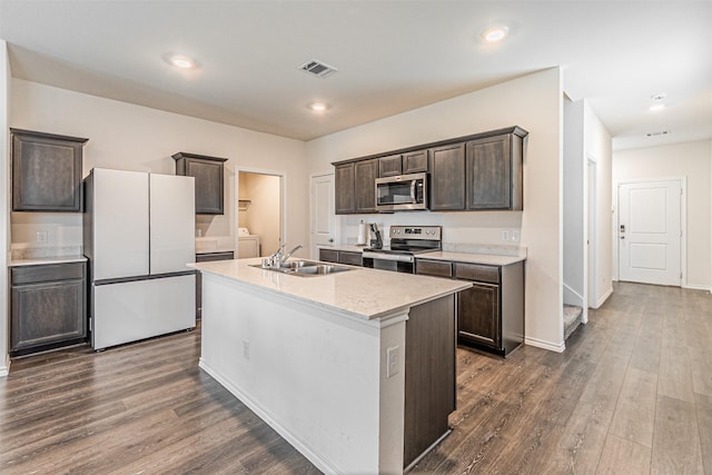 3233 Perman Dr, Mesquite, TX 75126 - kitchen featuring appliances with stainless steel finishes, dark brown cabinetry, dark wood finished floors, a kitchen island with sink, and recessed lighting