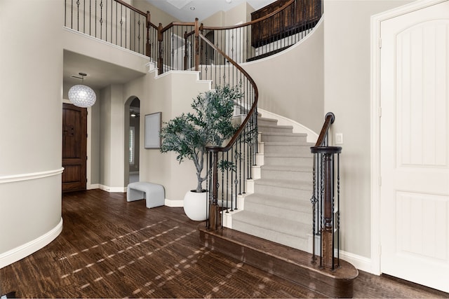 1505 Grove Dr, Celina, TX 75009 - staircase featuring arched walkways, a towering ceiling, and wood finished floors