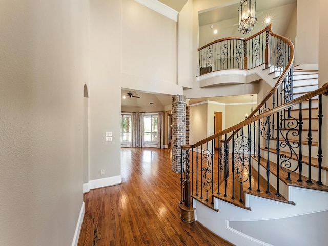 1016 Lighthouse Ct, Grand Prairie, TX 75104 - stairs featuring wood finished floors, arched walkways, a high ceiling, ceiling fan, and crown molding