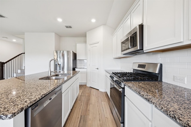 9114 S Field Ln, Arlington, TX 76002 - kitchen featuring stainless steel appliances, light wood-style flooring, white cabinetry, stone counters, and backsplash