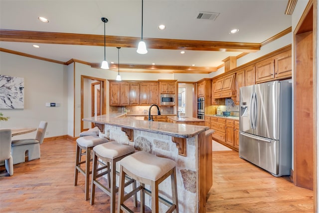 12624 Lake Shore Ct N, Fort Worth, TX 76179 - kitchen featuring stainless steel appliances, beam ceiling, light wood-type flooring, crown molding, and a kitchen bar