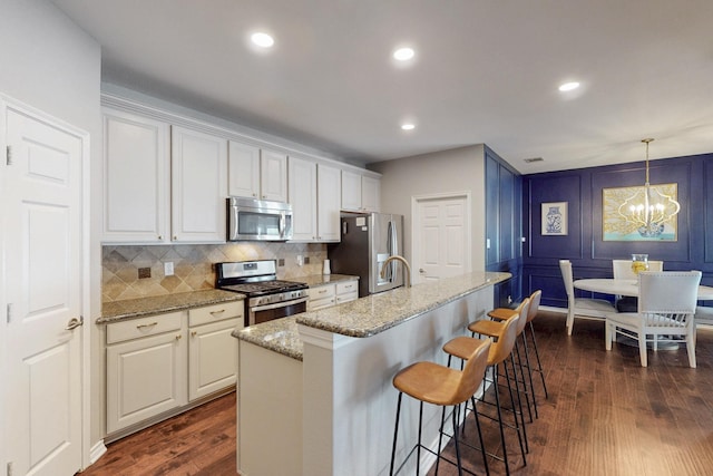1225 Long Leaf Dr, Savannah, TX 76227 - kitchen with stainless steel appliances, dark wood-style floors, an island with sink, white cabinetry, and recessed lighting