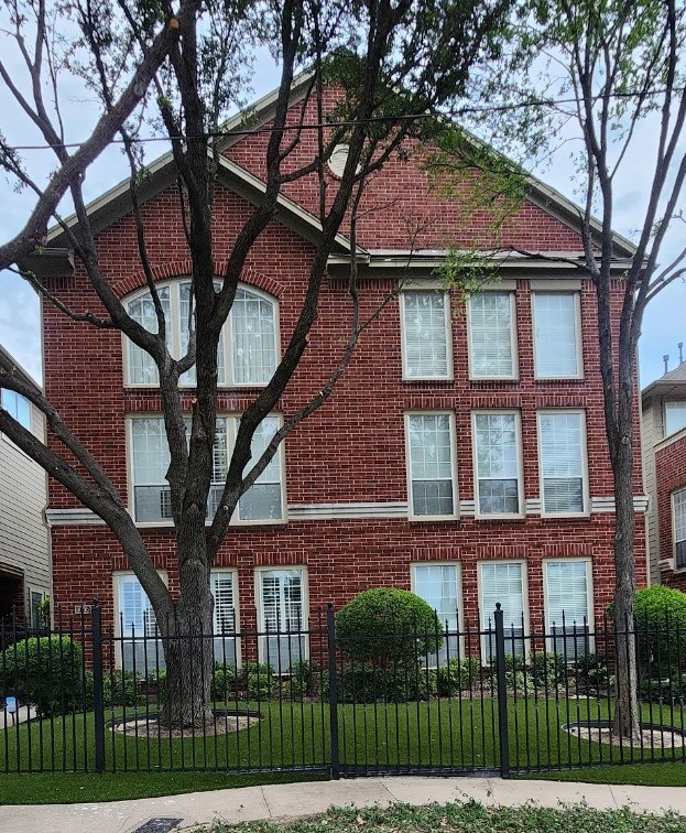 1005 W Bluff St, Fort Worth, TX 76102 - view of home's exterior featuring a fenced front yard and brick siding