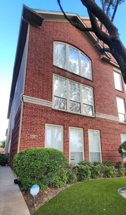 1005 W Bluff St, Fort Worth, TX 76102 - view of side of property featuring brick siding and a lawn