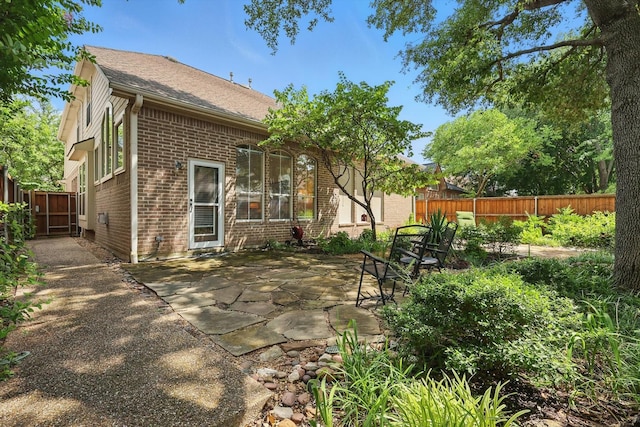 7939 Xavier Ct, Dallas, TX 75218 - back of property featuring brick siding, a patio, and a shingled roof