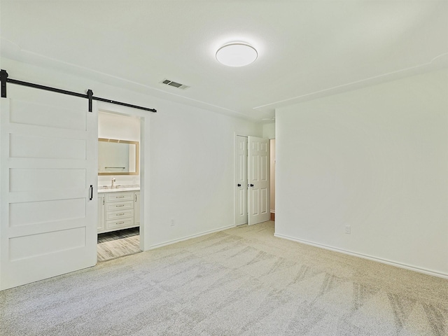 9101 Westwood Shores Dr, Fort Worth, TX 76179 - unfurnished bedroom with a barn door, light carpet, and ensuite bath