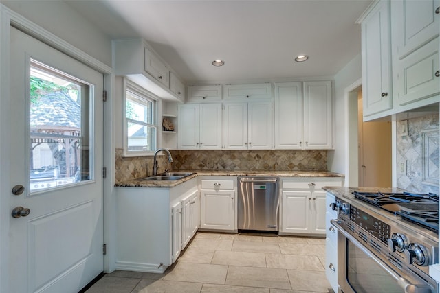 448 Parkhurst Dr, Dallas, TX 75218 - kitchen with appliances with stainless steel finishes, backsplash, white cabinetry, light stone counters, and recessed lighting