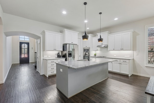 6305 Crossvine Trl, Flower Mound, TX 76226 - kitchen featuring stainless steel appliances, arched walkways, under cabinet range hood, decorative backsplash, and dark wood-style flooring