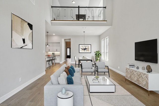 4131 Sandhills Ln, Prosper, TX 75078 - living area with a high ceiling, wood finished floors, and a chandelier