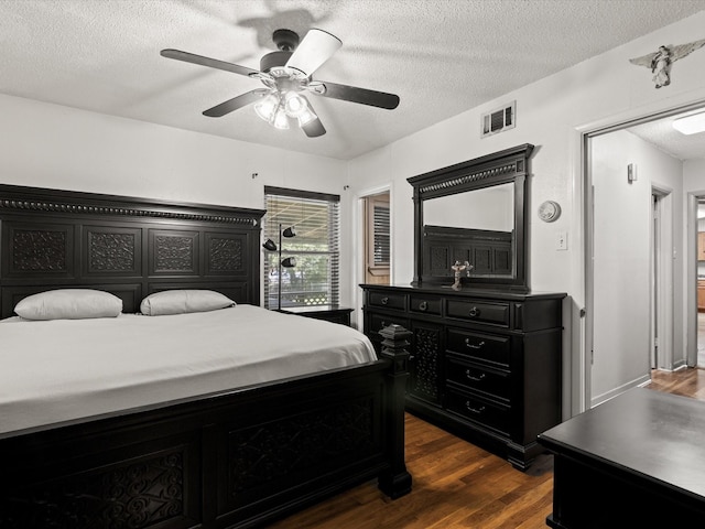301 Redbud, Ferris, TX 75125 - bedroom with a textured ceiling, dark wood finished floors, and ceiling fan