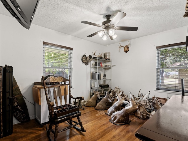 301 Redbud, Ferris, TX 75125 - interior space featuring wood finished floors, ceiling fan, and a textured ceiling
