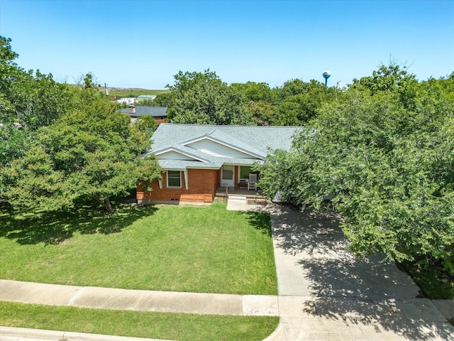 301 Redbud, Ferris, TX 75125 - view of front of house featuring a porch, concrete driveway, a front lawn, and roof with shingles