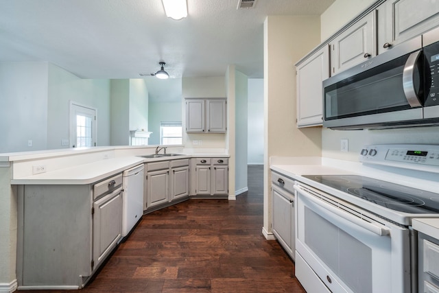 113 N W A Allen Blvd, Wylie, TX 75098 - kitchen with white appliances, a peninsula, dark wood-type flooring, light countertops, and gray cabinets