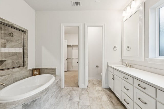 3623 Coldstream Dr, Irving, TX 75063 - bathroom with a garden tub, vanity, a walk in closet, and marble look tiles