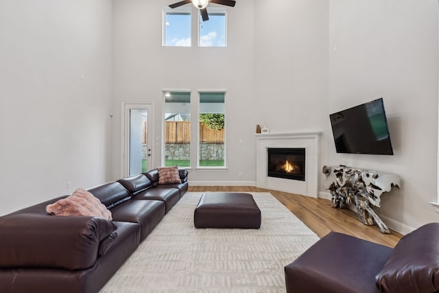 3623 Coldstream Dr, Irving, TX 75063 - living room featuring ceiling fan, a towering ceiling, a glass covered fireplace, and wood finished floors