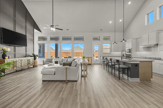 1715 Holly Oak Way, Fate, TX 75087 - living area with high vaulted ceiling, ceiling fan, light wood-type flooring, healthy amount of natural light, and recessed lighting