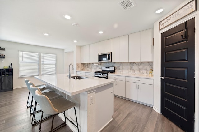 816 Adair Dr, Aubrey, TX 76227 - kitchen featuring stainless steel appliances, a breakfast bar, backsplash, light wood finished floors, and an island with sink