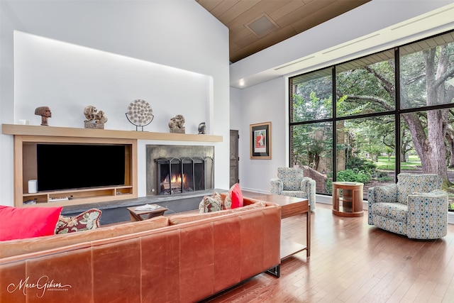 300 Pierremont Rd Unit 18, Shreveport, LA 71106 - living room with a warm lit fireplace, hardwood / wood-style floors, wood ceiling, and a towering ceiling