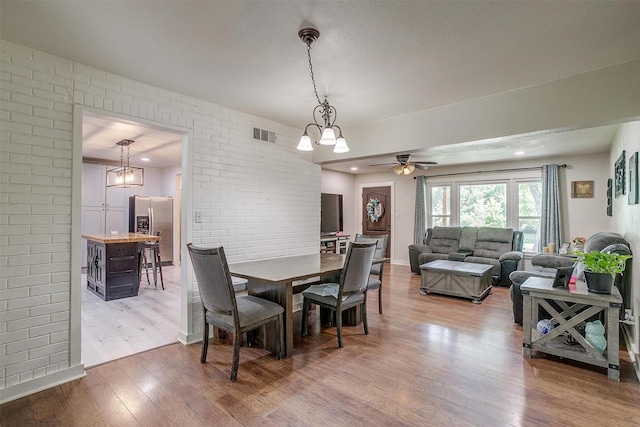 7063 Dover Ln, Richland Hills, TX 76118 - dining area with wood finished floors, ceiling fan, brick wall, and recessed lighting