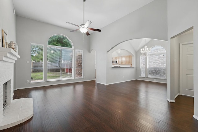 4704 Misty Ridge Dr, Fort Worth, TX 76137 - unfurnished living room with a fireplace, a ceiling fan, a chandelier, dark wood finished floors, and arched walkways