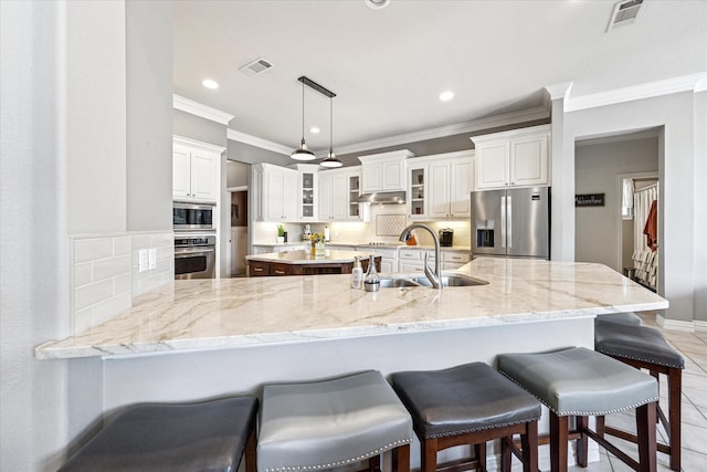 5651 Lucca Dr, Fort Worth, TX 76140 - kitchen with stainless steel appliances, crown molding, glass insert cabinets, a kitchen breakfast bar, and a peninsula