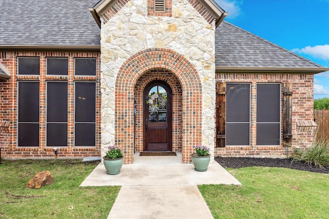 5651 Lucca Dr, Fort Worth, TX 76140 - property entrance featuring roof with shingles, brick siding, a yard, and stone siding