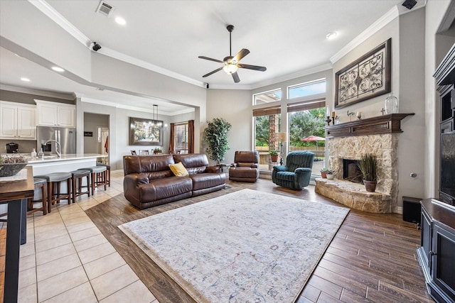 5651 Lucca Dr, Fort Worth, TX 76140 - living room featuring light wood finished floors, ceiling fan, a fireplace, crown molding, and a chandelier