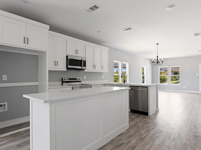 1609 E Bluff St, Fort Worth, TX 76102 - kitchen with stainless steel appliances, a kitchen island, healthy amount of natural light, a chandelier, and recessed lighting
