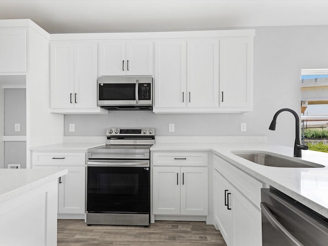 1609 E Bluff St, Fort Worth, TX 76102 - kitchen featuring stainless steel appliances, white cabinets, and light wood-style floors