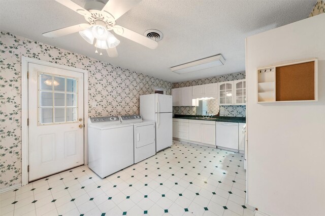 3808 Leland Ave, Waco, TX 76708 - kitchen with white appliances, under cabinet range hood, dark countertops, glass insert cabinets, and white cabinetry