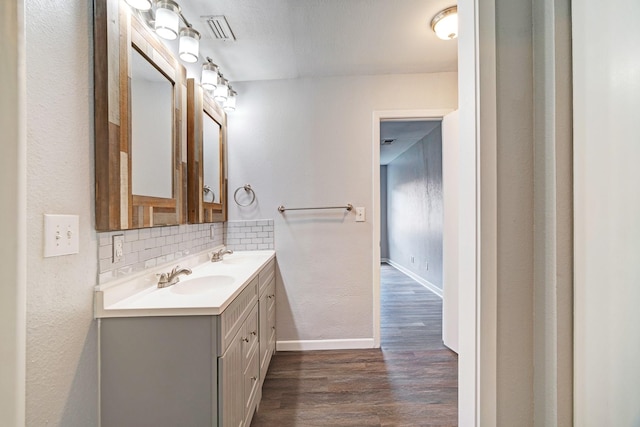2004 Blue Bird Cir, Bonham, TX 75418 - bathroom featuring vanity, decorative backsplash, wood finished floors, and a textured wall