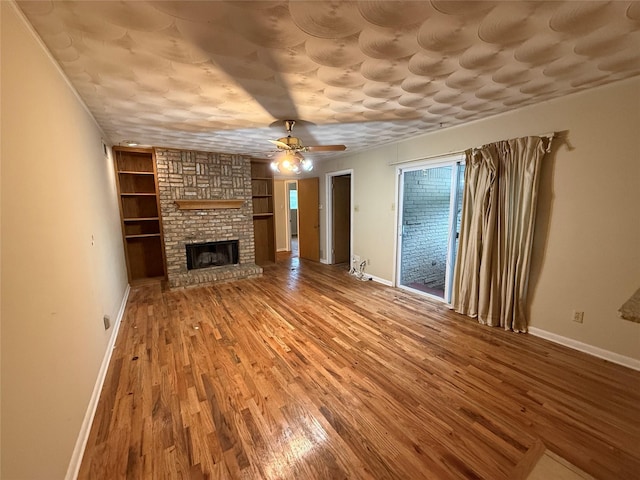 1237 Wagon Wheels Trl, Dallas, TX 75241 - unfurnished living room featuring ceiling fan, wood finished floors, and a brick fireplace