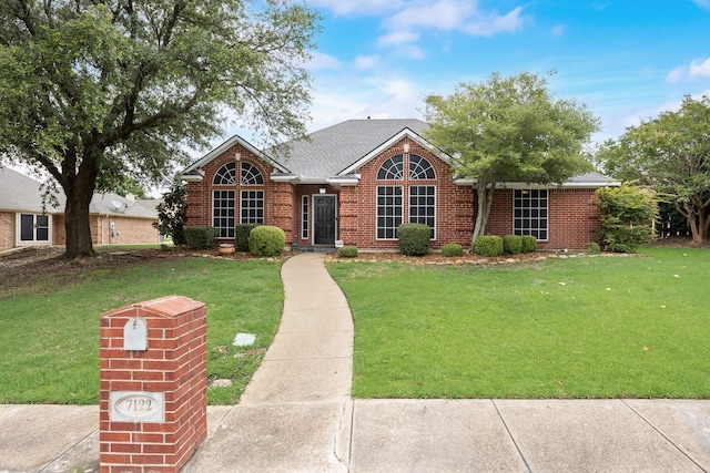 7122 Holden Dr, Rockwall, TX 75087 - traditional home featuring brick siding, a front lawn, and roof with shingles