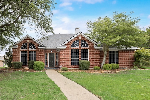 7122 Holden Dr, Rockwall, TX 75087 - view of front of property with a front yard, brick siding, a chimney, and roof with shingles