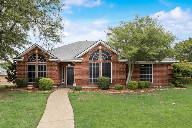 7122 Holden Dr, Rockwall, TX 75087 - view of front of home with a front yard, brick siding, and a shingled roof